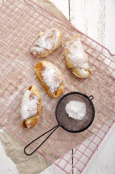 Croissant con azúcar en polvo en un estante de cocina —  Fotos de Stock