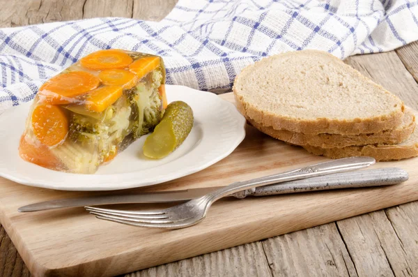 Vegetable aspic and bread on a wooden board — Stock Photo, Image