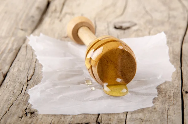 Honey dipper on kitchen paper — Stock Photo, Image