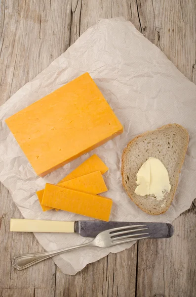 Irlandês queijo cheddar maduro no papel — Fotografia de Stock