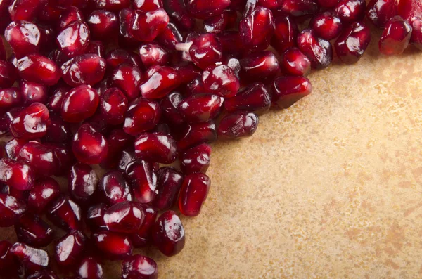 Pomegranate seed on a brown background — Stock Photo, Image