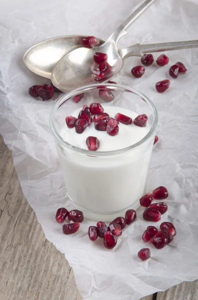 Yogurt in a glass with pomegranate seed — Stock Photo, Image