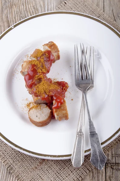 Curried sausage with ketchup on a plate — Stock Photo, Image