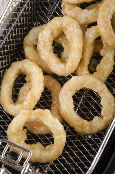 Anéis de cebola fritos frescos fora de uma fritadeira — Fotografia de Stock