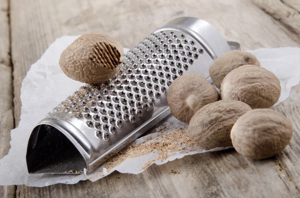 Grated nutmeg and powder on paper — Stock Photo, Image