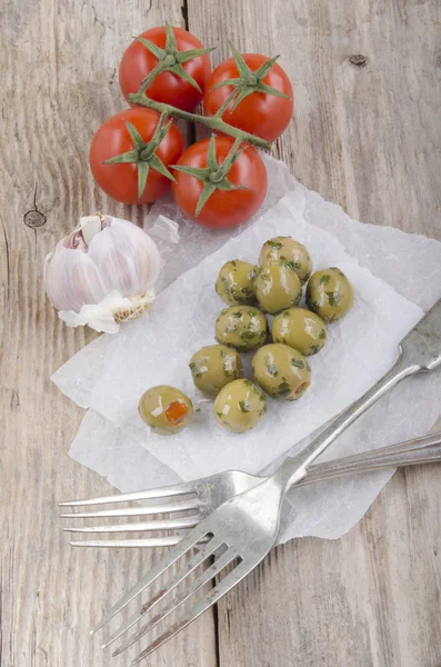 Green stuffed spicy olive on white paper — Stock Photo, Image