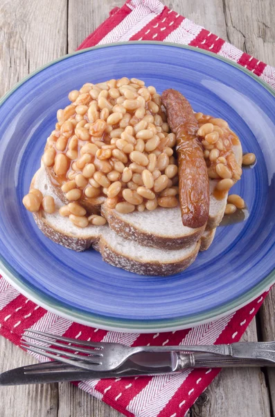 Sausage with baked beans on bread — Stock Photo, Image