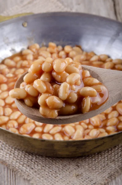 Wooden spoon with baked beans — Stock Photo, Image