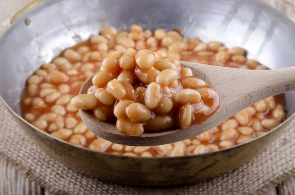 Wooden spoon with baked beans — Stock Photo, Image