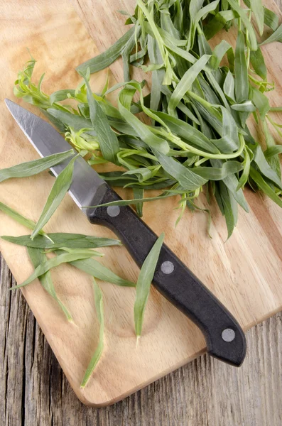 Tarragon and kitchen knife on wooden board — Stock Photo, Image