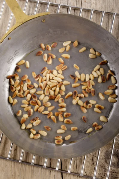 Жареные кедровые орехи в кастрюле — стоковое фото