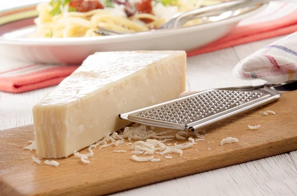 Fromage parmesan et râpe sur bois — Photo