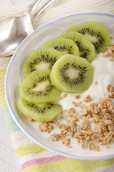 Yogurt with kiwi slice and cereals — Stock Photo, Image