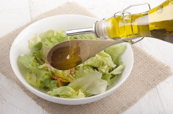 Olíva olajat öntenek egy tál saláta — Stock Fotó