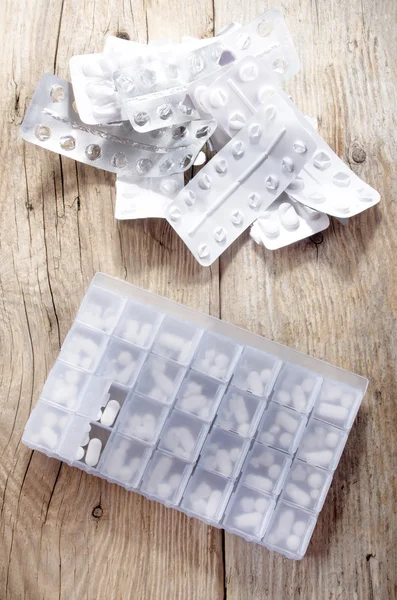 Fyllda piller dispenser på rustika trä — Stockfoto