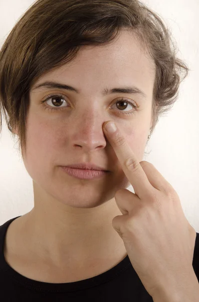 Woman holding the middle finger under her eye — Stock Photo, Image