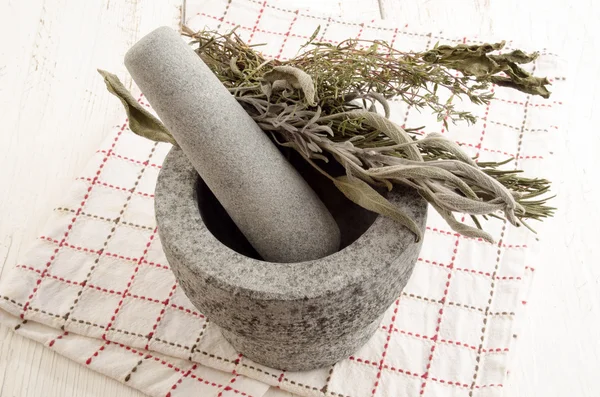 Pestle dengan herbal kering dan handuk dapur — Stok Foto