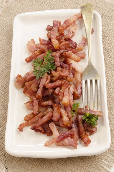 Gegrilde baconbits op een plaat — Stockfoto