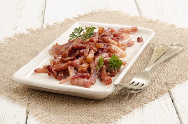 Grillad bacon bitar på en tallrik — Stockfoto