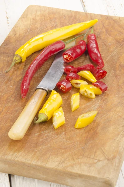 Chili peppers na dřevěném prkénku — Stock fotografie