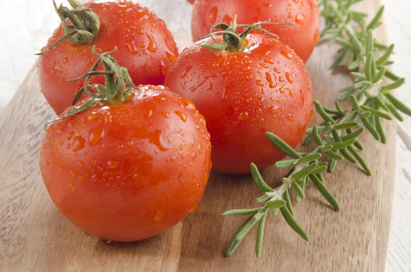 Влажный органический помидор с розмарином — стоковое фото