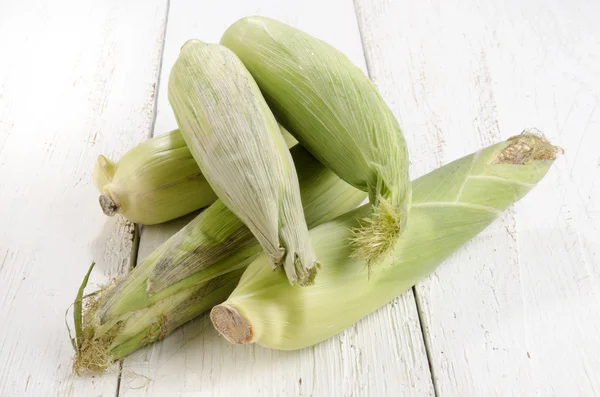 Freshly harvested corn cobs on a kitchen table — Stock Photo, Image