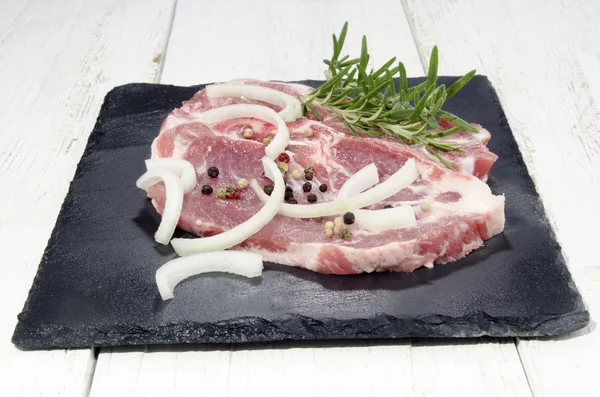 Schweineschulter in Scheiben geschnitten mit Zwiebeln und Rosmarin — Stockfoto