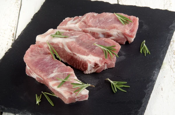 Ribs with rosemary on slate — Stock Photo, Image