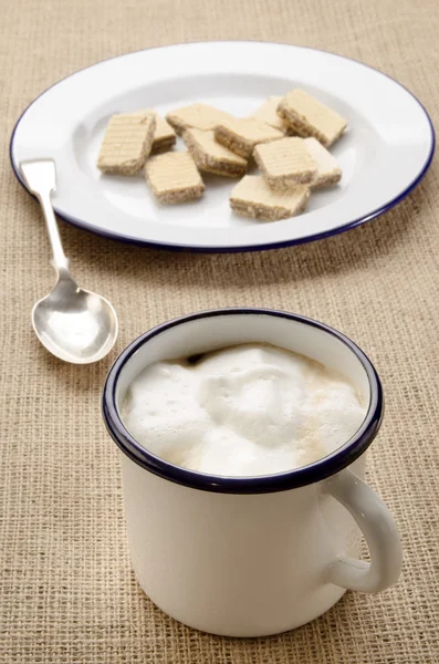 Café com espuma de leite em uma caneca de esmalte — Fotografia de Stock