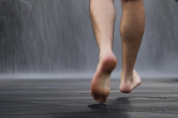 Man walking in the rain barefoot — Stock Photo, Image