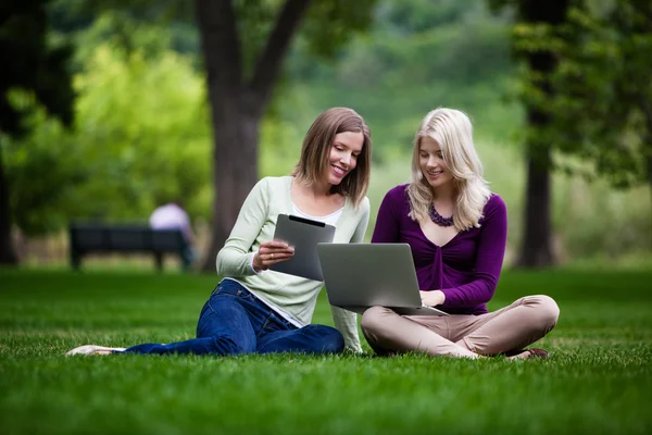 Mujeres jóvenes en el parque con tecnología — Foto de Stock