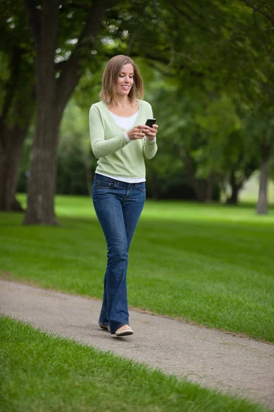 Kvinna textmeddelanden i park — Stockfoto