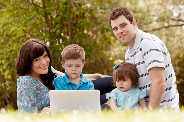 Familia al aire libre con computadora — Foto de Stock