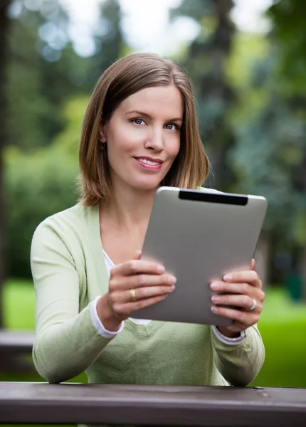 Žena v parku s digitálním tabletu — Stock fotografie