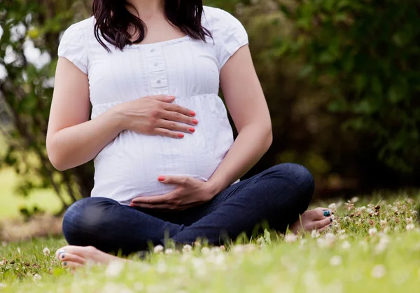 Ansiktslösa gravid kvinna i park — Stockfoto