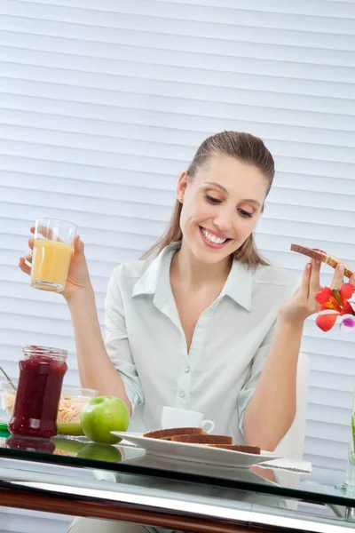 Mulher feliz tendo suco de laranja — Fotografia de Stock