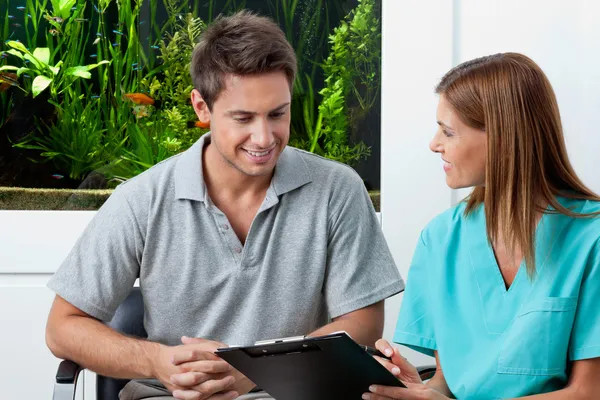 Arts en mannelijke patiënt in tandheelkundige kliniek — Stockfoto