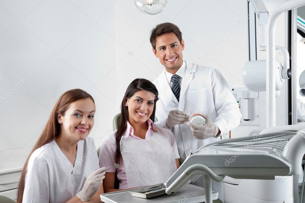 Dentist And Nurse With Patient In Clinic