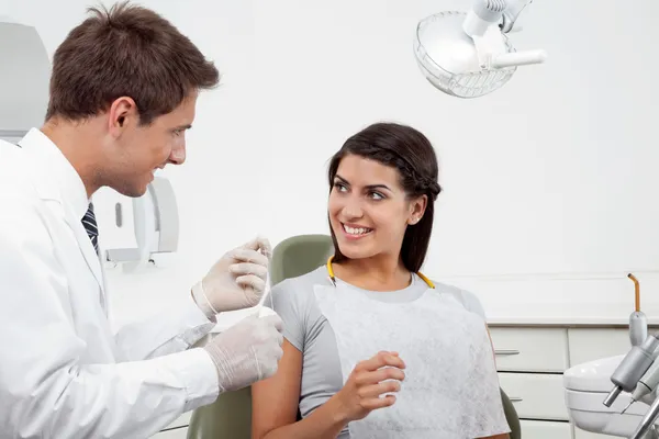 Dentist Holding Thread While Patient Looking At Him Royalty Free Stock Images