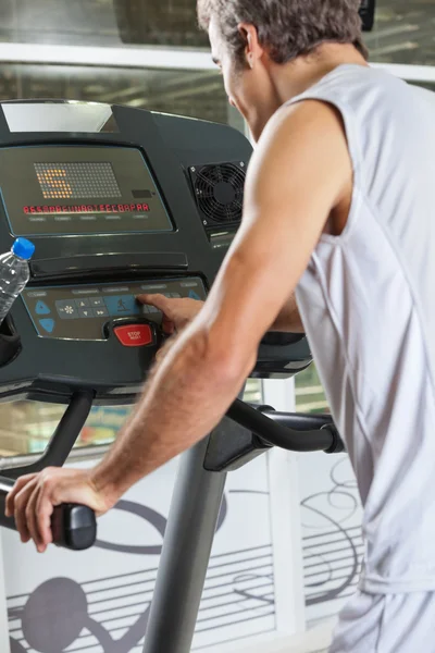 Homme appuyant sur le bouton du programme sur tapis roulant — Photo