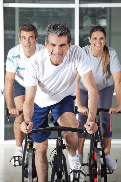 Mannen en vrouw op spinnen fietsen — Stockfoto