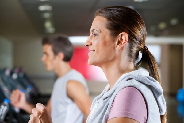 Femme et homme courir sur tapis roulant — Photo