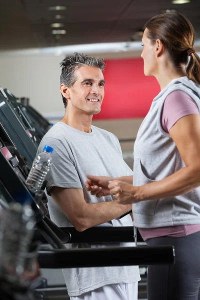 Kadın müşteri treadmill egzersiz bakarak eğitmen — Stok fotoğraf