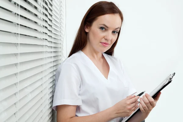 Dentiste féminine confiante tenant le panneau de clip et le stylo — Photo