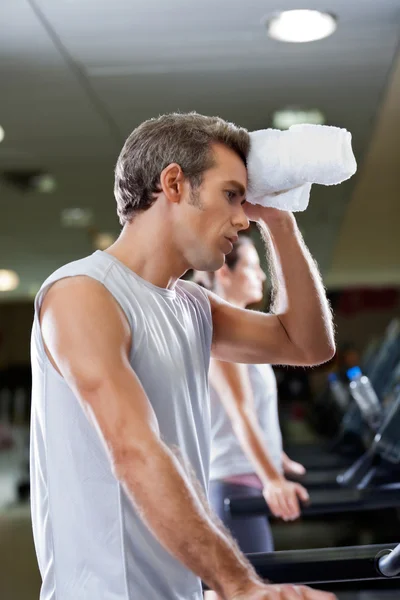 Man Wiping Sweat With Towel At Health Club Stock Picture