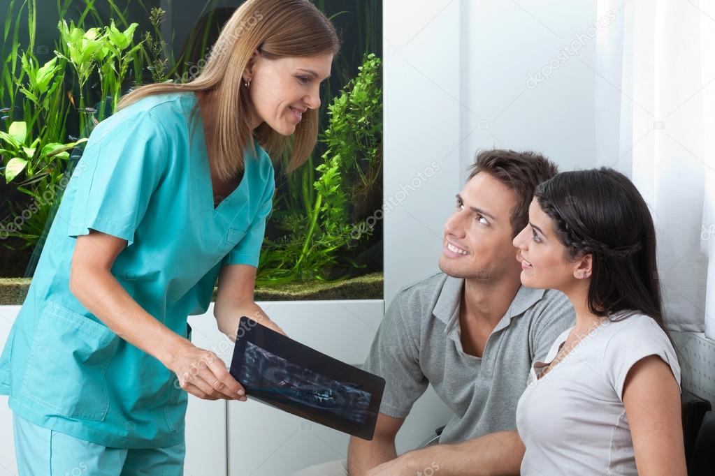 Dentist Showing Dental X-Ray To Couple
