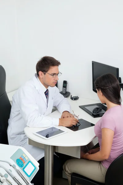 Dentista mostrando informe de rayos X al paciente — Foto de Stock