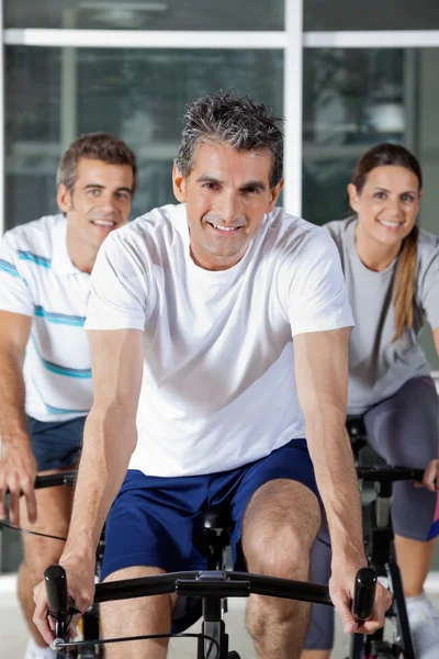 Três em bicicletas de exercício — Fotografia de Stock