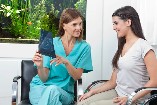 Стоматолог показує рентгенівський звіт жінці — стокове фото