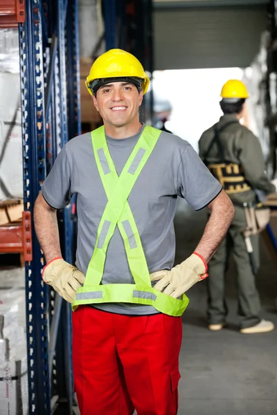 Mid volwassen foreman met handen op de heupen magazijn — Stockfoto